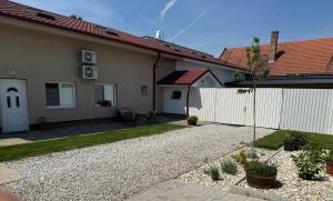 a house with a gravel driveway and a fence at Ubytovanie Stavbar in Štúrovo