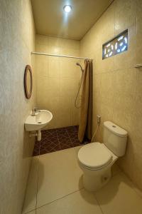 ein Badezimmer mit Toilette und Waschbecken in der Unterkunft Pudak Sari Homestay in Kuta