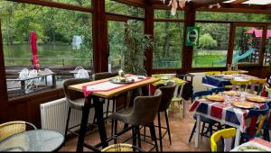 a restaurant with tables and chairs and a large window at le Gite de illian in Saint-Michel