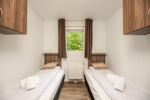 Ένα ή περισσότερα κρεβάτια σε δωμάτιο στο Forest lodge with enclosed garden I 4 people copy +13 φωτογραφίες