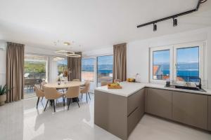a kitchen and dining room with a table and chairs at Villa SUNSET II with private pool and beautiful sea view in Vrbnik