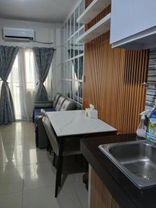 a kitchen with a sink and a living room with a couch at Paranaque Manila Bloom residences in Manila