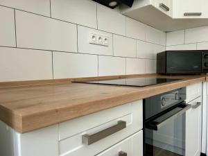 a kitchen with a wooden counter top and a microwave at Chata Majlont in Malá Vrbka