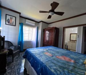 a bedroom with a bed and a ceiling fan at Sukasa Ville in Montego Bay