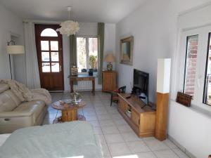 a living room with a couch and a tv at Maison de charme dans la Somme in Miraumont