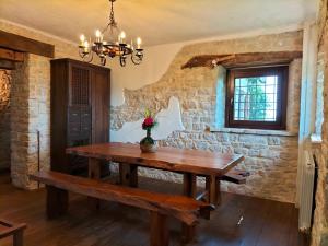 ein Esszimmer mit einem Holztisch und einer Bank in der Unterkunft Ferienhaus für 10 Personen in Penna San Giovanni, Marken Provinz Macerata in Penna San Giovanni + 32 Fotos