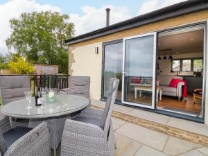 a patio with a table and chairs on a balcony at Highview Stables in Chesterfield
