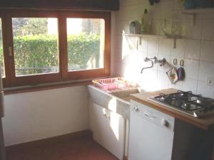 una cucina con fornello forno superiore accanto a una finestra di Appartement Mit Grill, Gemeinsamem Pool Und Garten a Bibbiena