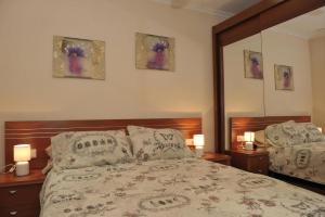 a bedroom with a bed with two lamps and a mirror at Yovalu1 in Torrevieja