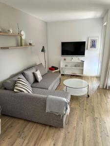 a living room with a couch and a tv at Entennest am Dorfteich in Wenningstedt