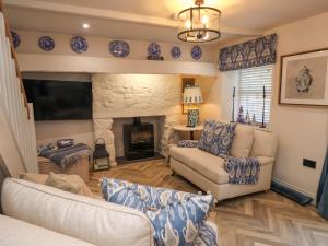 a living room with a couch and a fireplace at 6 Uppergate Street Rose Cottage in Conwy