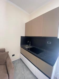 a kitchen with a sink and a couch at La casa della stazione in La Spezia