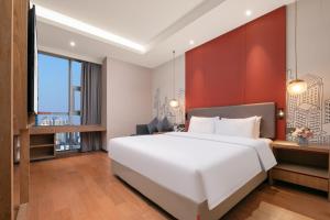 Postel nebo postele na pokoji v ubytování Mansion New Century Hotel Chengdu Wuhou