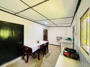 a dining room with a table and chairs and a kitchen at Chaaya Cottage in Bentota