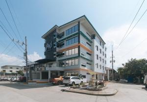 a tall building with cars parked in front of it at Sans Hotel near Enchanted Kingdom Santa Rosa Laguna in Santa Rosa