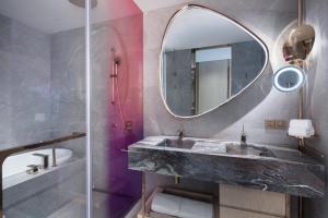 a bathroom with a marble sink and a mirror at W Chengdu in Chengdu