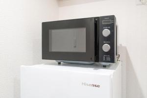 a microwave sitting on top of a white refrigerator at Laina Kyobashi2 in Osaka +13 photos