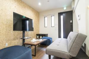 a living room with a couch and a tv at Laina Kyobashi2 in Osaka