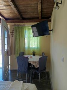 a dining room with a table and chairs and a tv at Panorama Studio in Skradin
