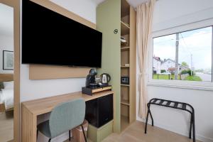 a room with a desk and a tv and a chair at Green Inn in Velika Gorica