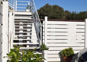 Una valla blanca con escaleras en un patio. en Moon - Casa Vacanze, en Su Forti