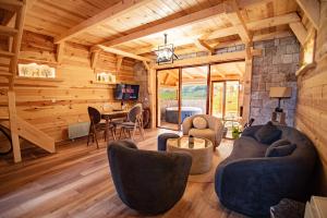 a living room in a log cabin with a table and chairs at Prima Vista 2 in Žabljak
