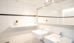 a white bathroom with two sinks and a mirror at Papyrer Apartment - Stilvolles Apartment in Lenggries in Lenggries