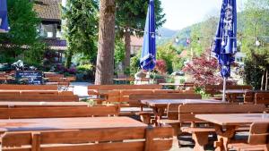 a group of wooden tables and chairs with umbrellas at Papyrer Apartment - Stilvolles Apartment in Lenggries in Lenggries