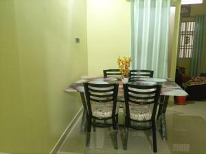 una mesa de comedor con 4 sillas y un jarrón con flores en jajabor Homestay, en Jāmb