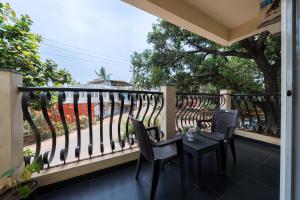 Un balcón con dos sillas y una mesa. en Helloworld Riverbank Inn, en Morjim