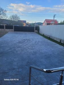 an empty parking lot with a white fence at Casa Georgia in Târgu Ocna