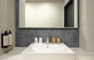 a white sink in a bathroom with a mirror at Great Polonia Umi Hotel Sopot in Sopot