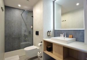 a bathroom with a toilet and a sink and a shower at Great Polonia Umi Hotel Sopot in Sopot