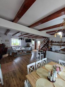a kitchen and living room with wooden ceilings and tables at Casa Marandy in Sadu