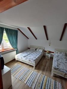 a bedroom with two beds and a window at Casa Marandy in Sadu +23 photos