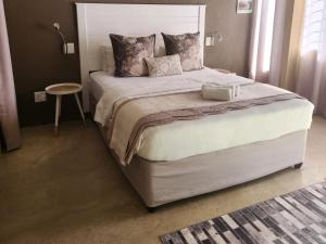 1 dormitorio con 1 cama grande y mesa en Willow Inn, en Nelspruit