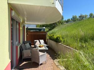 a patio with wicker chairs and a table on a house at Ferienwohnung "Seeperle" Marina Mücheln Geiseltalsee in Mücheln