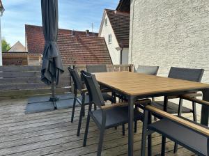 a wooden table and chairs on a deck with an umbrella at Große Freiheit in Ellzee