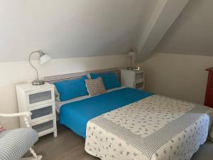 a bedroom with a blue bed and a night stand at I Pini Apartment in Eraclea Mare