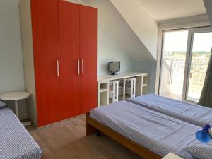 a bedroom with a red cabinet and a bed at I Pini Apartment in Eraclea Mare +2 photos