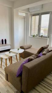 a living room with a couch and two tables at Apartman Dina in Sanski most