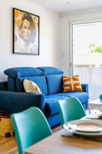 a living room with a blue couch and chairs at Cassis Le Capucine in Cassis