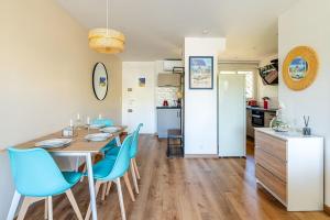 a dining room with a table and blue chairs at Cassis Le Capucine in Cassis