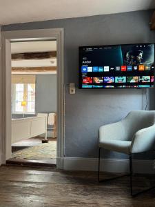 a living room with a television on the wall at Millers Kate mit Elbblick in Lauenburg