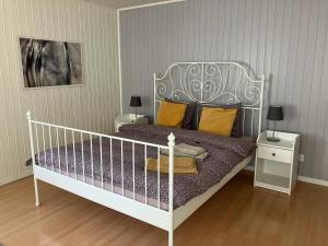 a bedroom with a white bed with yellow pillows at La Lanterne in Sierre