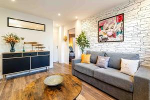 a living room with a couch and a brick wall at Cassis Le Marignan in Cassis