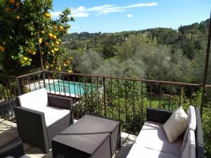 a balcony with an orange tree and a pool at Beautiful private villa with open views in Valbonne
