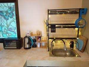 eine Küche mit Spüle und Mikrowelle in der Unterkunft Butterfly Cottage Tracy Island Had Yao in Ko Phangan