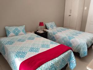two beds sitting next to each other in a bedroom at Silverstreams Guest house in Mthatha