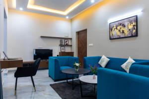a living room with a blue couch and a table at Buteak Suites BTM Layout in Bangalore